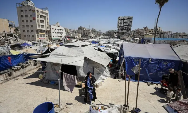  (غزہ سٹی میں بے گھر افراد کے کیمپ میں ایک فلسطینی خاتون خیموں کے درمیان کھڑی ہے، 28 اپریل 2026) 